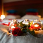 mood lighting, candles and roses on the bed