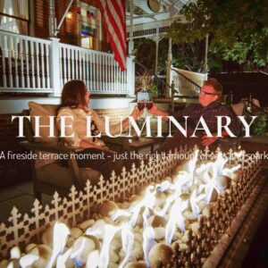 Fall in Love with Parkville: Couple enjoying wine next to a fire pit at night outside the Main Street Inn, with cozy autumn ambiance and glowing flames