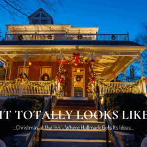 Exterior view of Main Street Inn at dusk with twinkle lights, garland, and wreaths glowing from the porch.