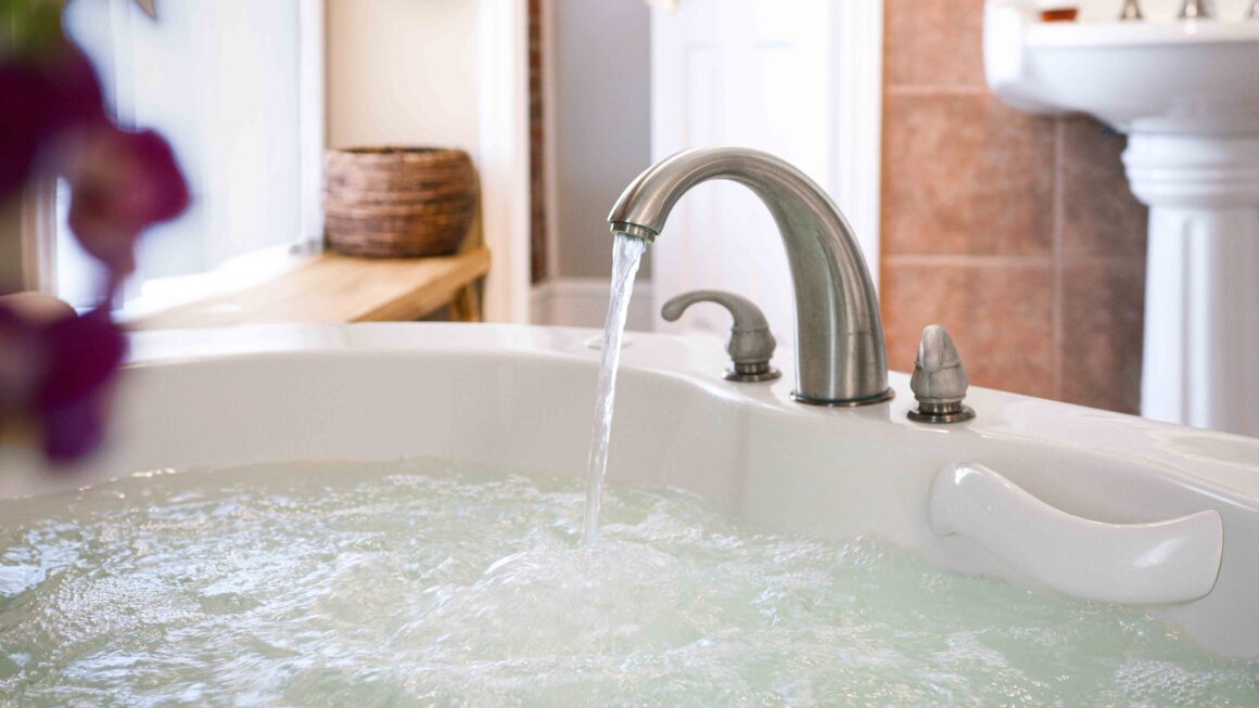 Close-up view of water flowing into the jacuzzi tub inside the Colonel Park Suite.