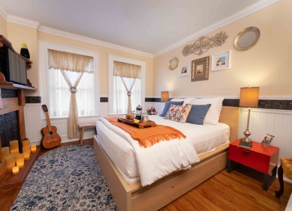 Romantic bed and breakfast room with a vintage fireplace and warm candlelight in Old Kate’s Room at Main Street Inn.