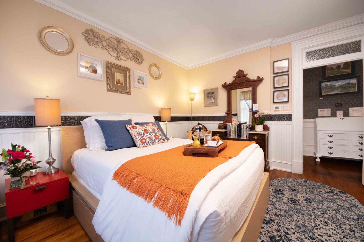 Wide-angle view of Old Kate’s Room showing the bed, dresser, reading chair, and overall cozy layout.