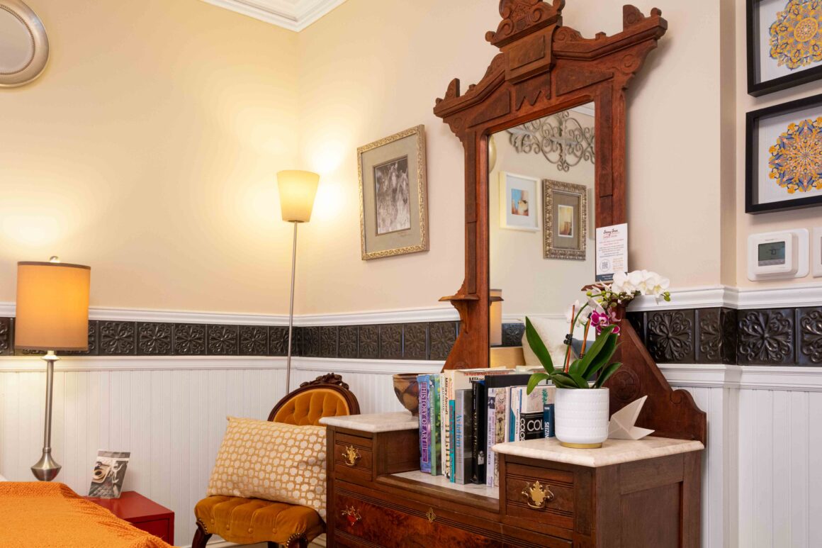 Close-up of the antique dresser mirror and orchid arrangement inside Old Kate’s Room.