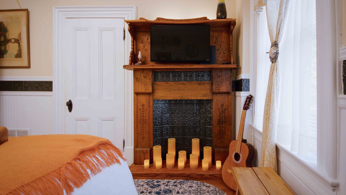 Close-up of the decorative fireplace with candles inside Old Kate’s Room.