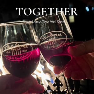 Couple enjoying a quiet evening by the fire with wine glasses at a romantic bed and breakfast in Parkville Missouri