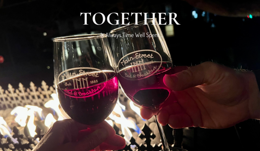 Couple enjoying a quiet evening by the fire with wine glasses at a romantic bed and breakfast in Parkville Missouri