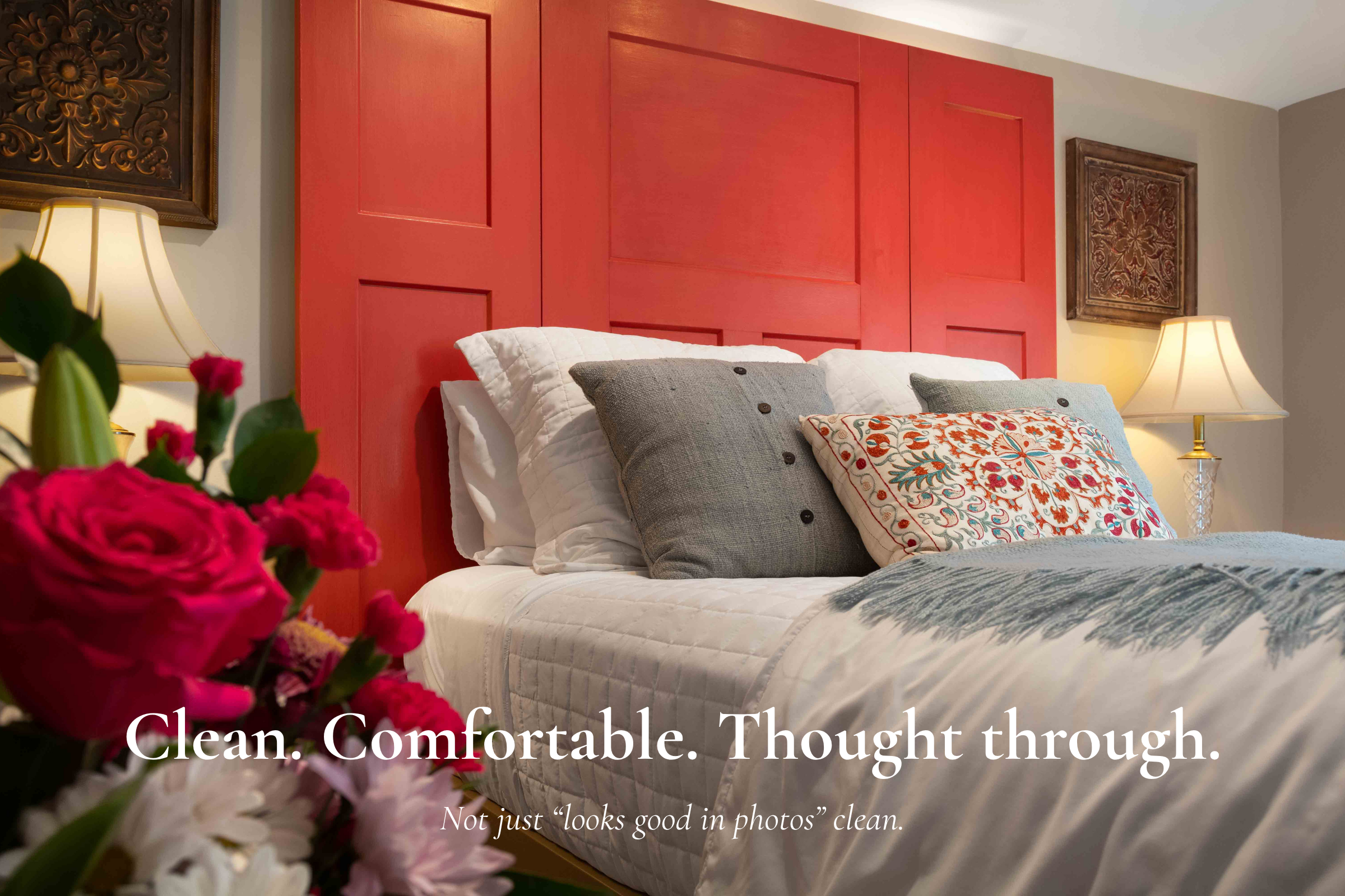 Guest room at Main Street Inn with red headboard and clean comfortable bedding
