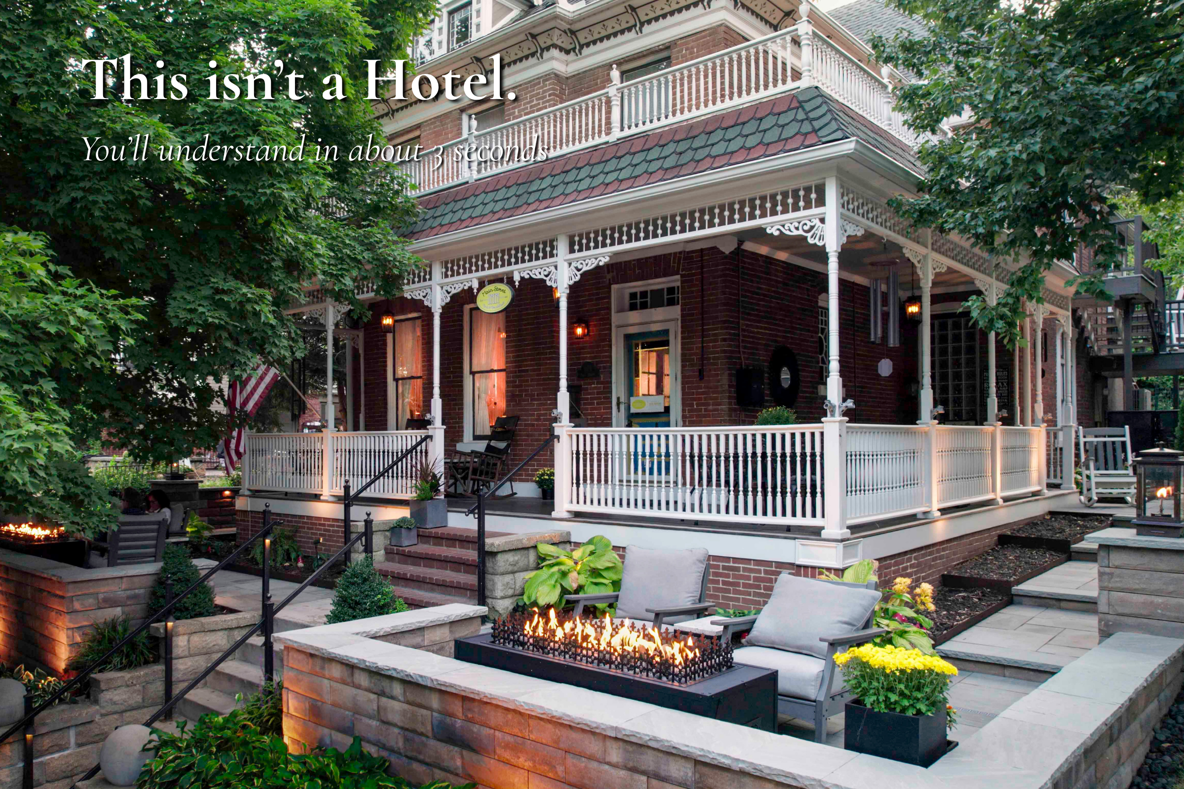 Main Street Inn exterior in Parkville Missouri with front porch and fire feature at dusk