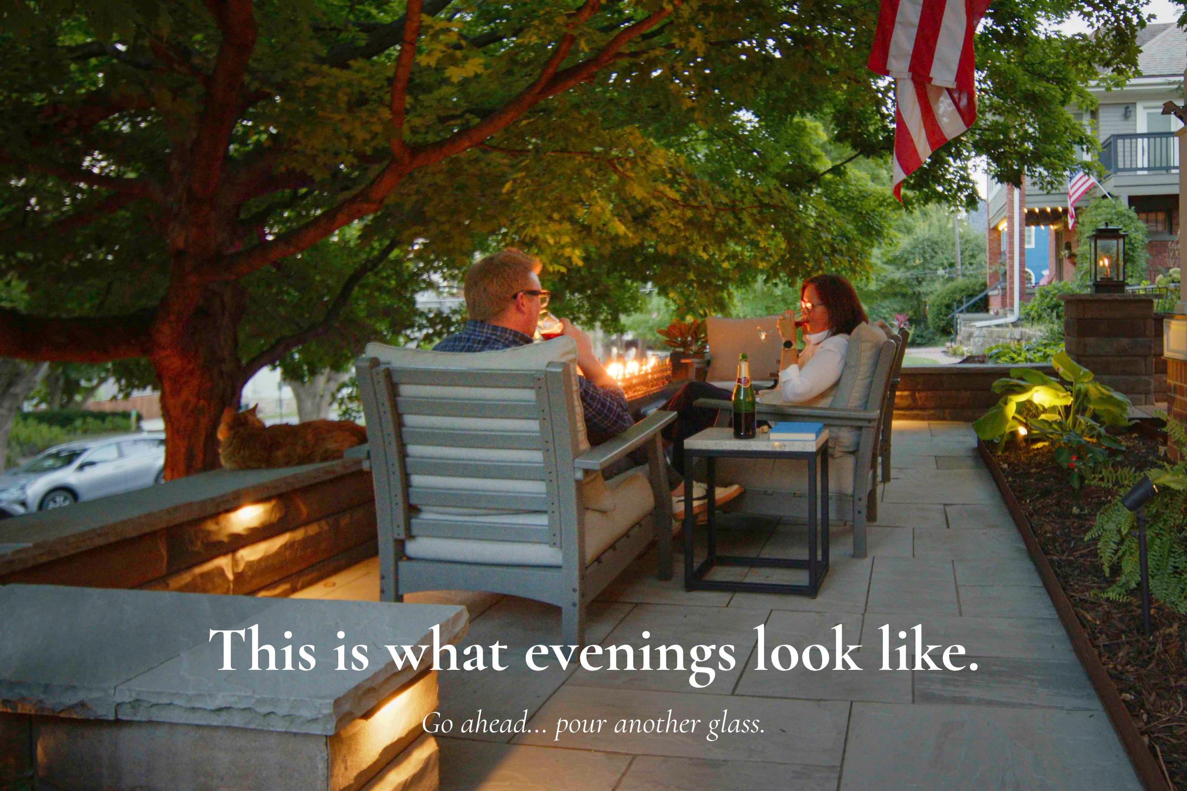 Guests relaxing by fire pit on patio at Main Street Inn in the evening