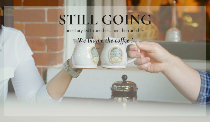 Two mugs raised in a toast at the Main Street Inn with overlay text reading “Still Going” reflecting on one year of stories and journaling.